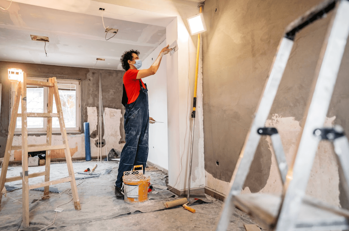 painting his wall in dungareed